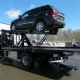 Camion-plateforme transportant un SUV noir