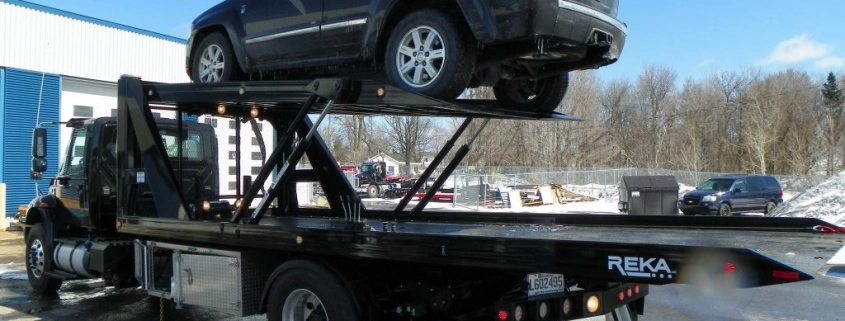 Camion-plateforme transportant un SUV noir