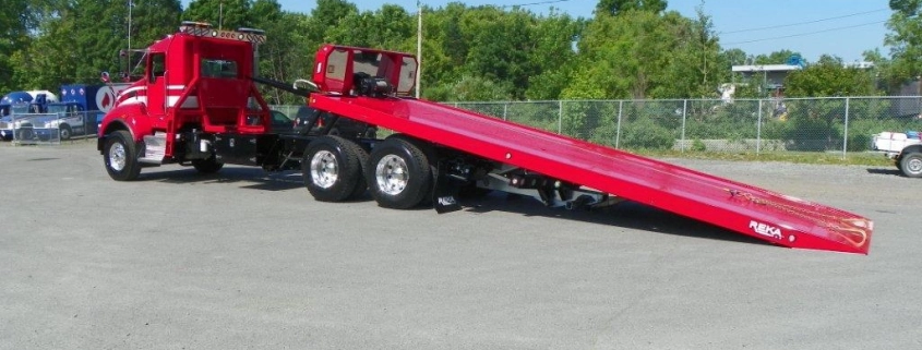 Camion de remorquage rouge avec rampe incliné